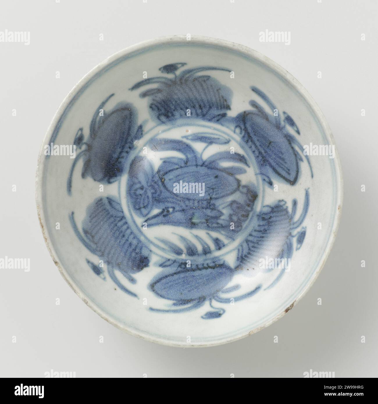 Plat de V.o.c.-ship le 'Witte Leeuw', Anonyme, avant 1613 plat de v.o.c. ship le 'Witte Leeuw', 100 présents. Le bol est plat avec un mur presque droit. L'anneau de pied est bas et facetté d'un côté. Le bol est fait d'argile de bonne qualité et a peu d'impuretés. Le fond est convexe, a des crêtes radiales et du sable de four a été trouvé dessus. Le glaçage est bleu teinté et mince avec des fissures et des trous d'épingle. L'appartement de l'intérieur est décoré de plantes de lotus en fleurs avec un canard en dessous. Jingdezhen porcelaine lotus  ornement - AA - stylisé Sint-Helena Banque D'Images