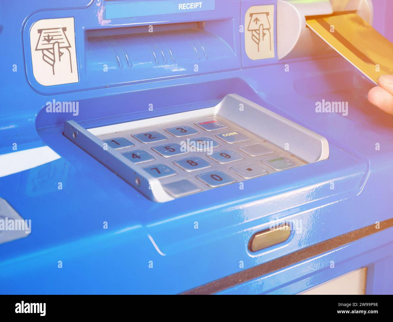 Main féminine insérant la carte ATM dans la machine bancaire ATM pour retirer de l'argent Banque D'Images