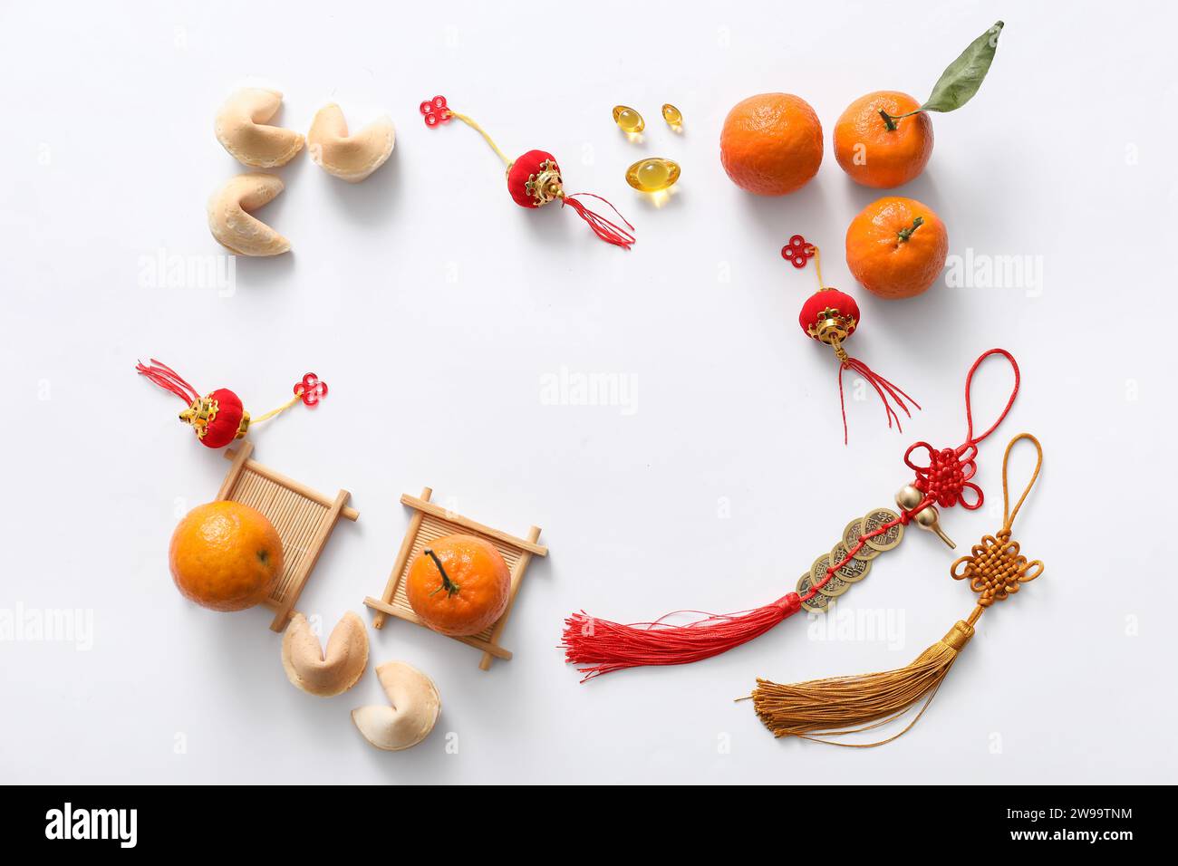 Cadre fabriqué à partir de talismans chanceux, biscuits de fortune, mandarines et symboles chinois sur fond blanc. Célébration du nouvel an. Célébration du nouvel an Banque D'Images