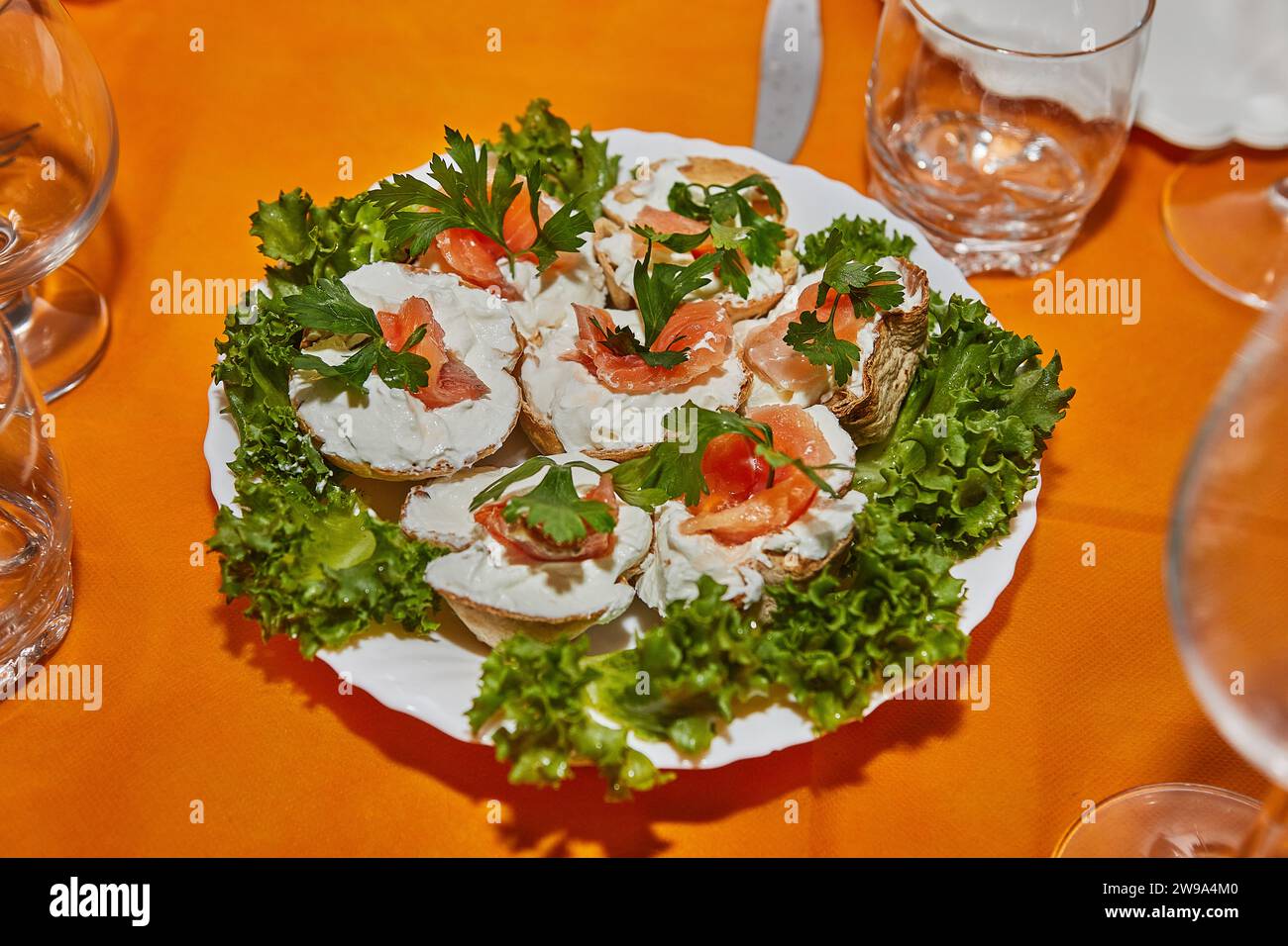 Table de fête du nouvel an magnifiquement arrangée avec paniers de fromage, saumon frais et verts vibrants, créant une atmosphère élégante et accueillante Banque D'Images