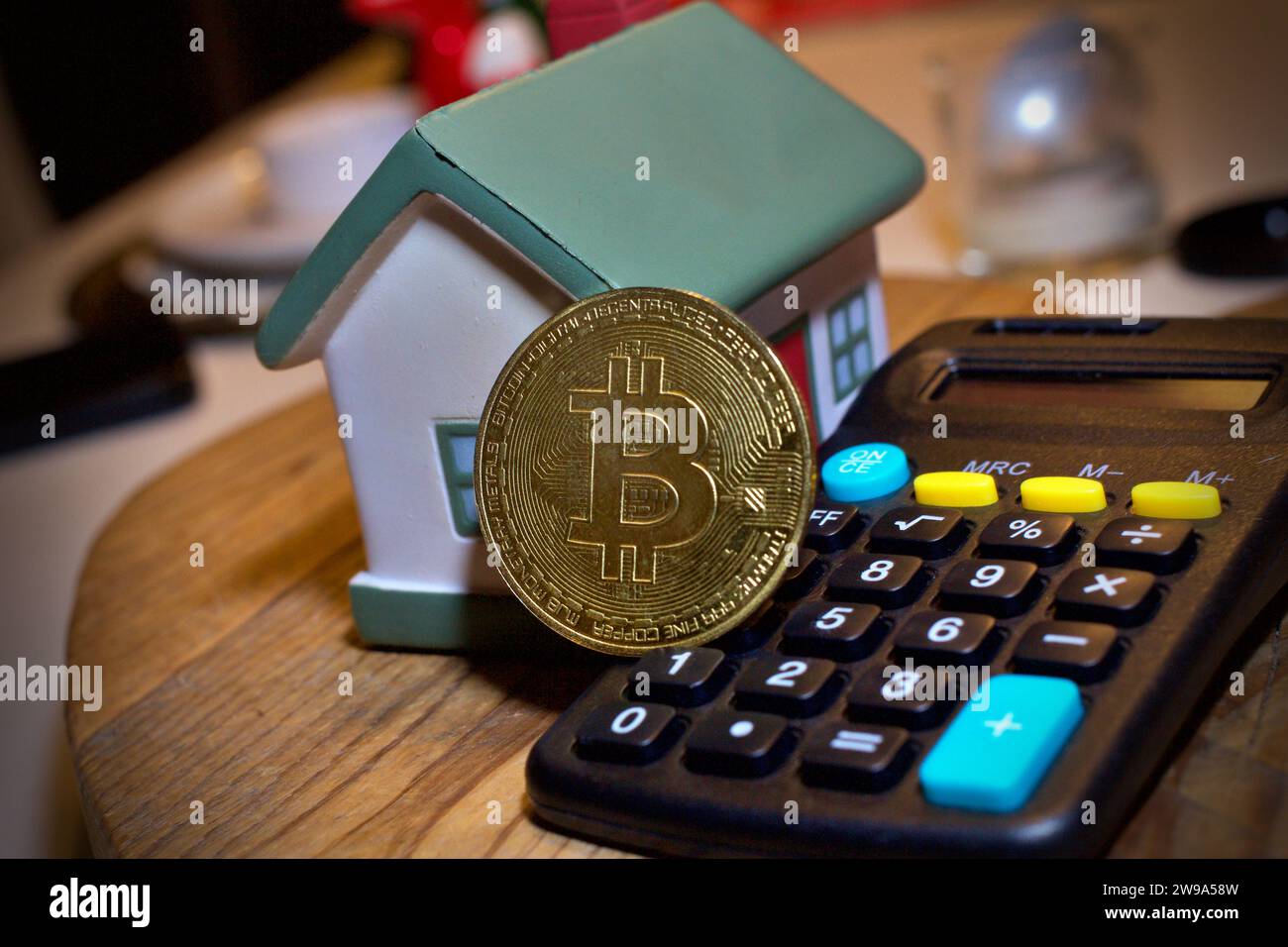 Des objets dans la maison et une calculatrice avec une pièce Bitcoin au milieu. Concept de crypto coin . Banque D'Images