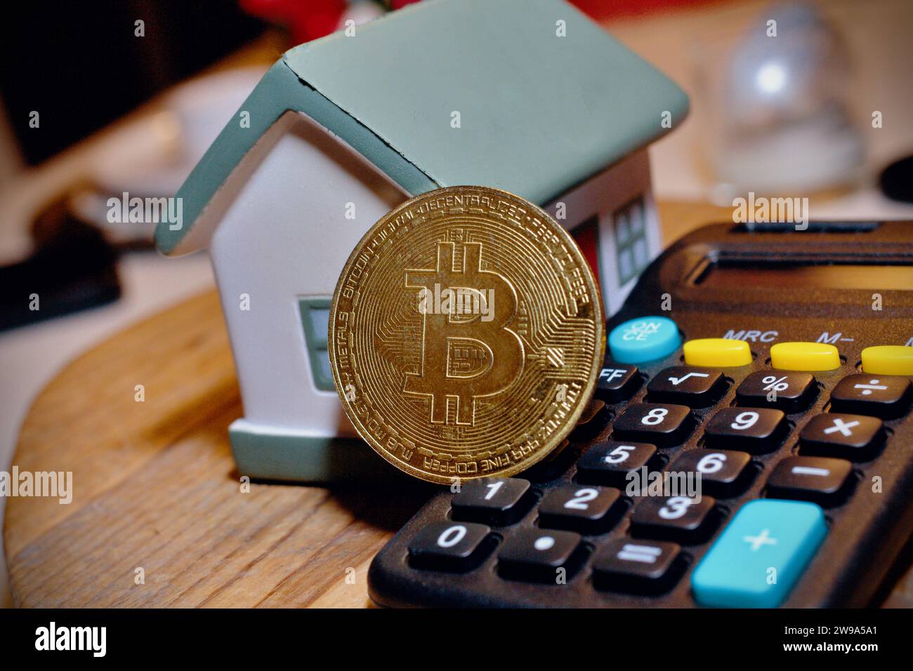 Des objets dans la maison et une calculatrice avec une pièce Bitcoin au milieu. Concept de crypto coin . Banque D'Images