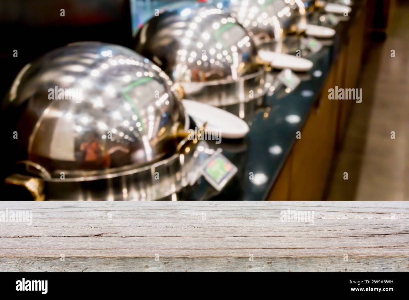 dessus de table en bois sur les plateaux chauffants de buffet prêt pour le service flou arrière-plan avec la lumière bokeh Banque D'Images