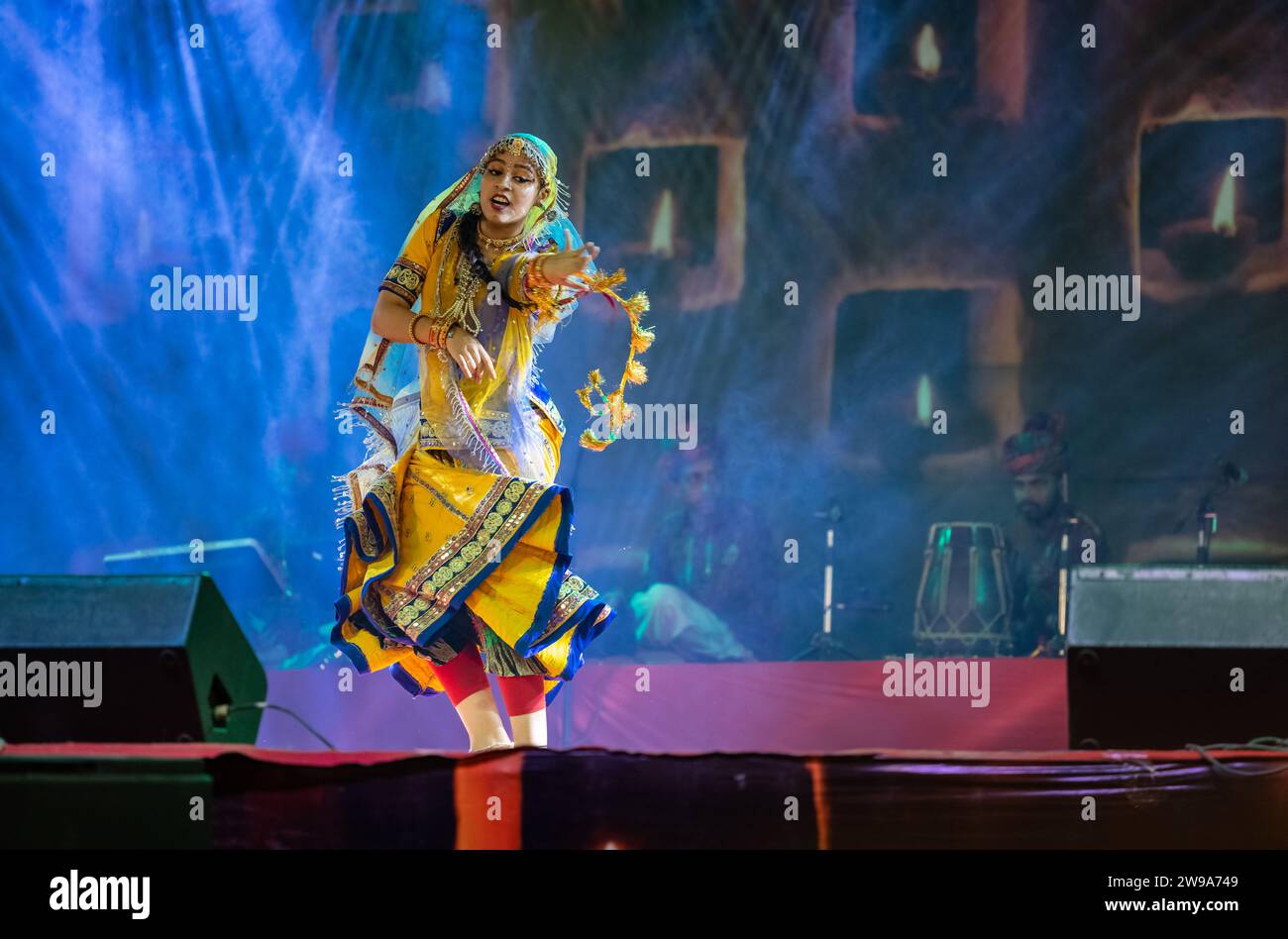 Portrait d'une jeune belle artiste féminine exécutant de la danse sur une chanson pendant la foire de pushkar en robe colorée ethnique rajasthani. Banque D'Images