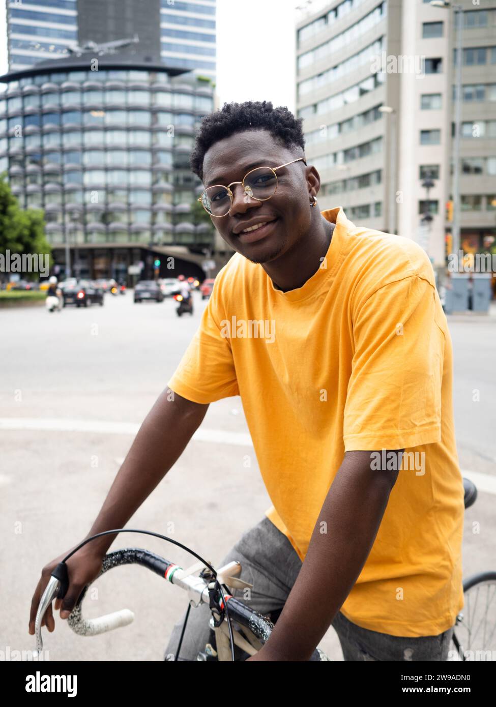 Jeune homme afro-américain souriant avec un vélo dans la ville. Mobilité durable, mode de vie millénaire Banque D'Images