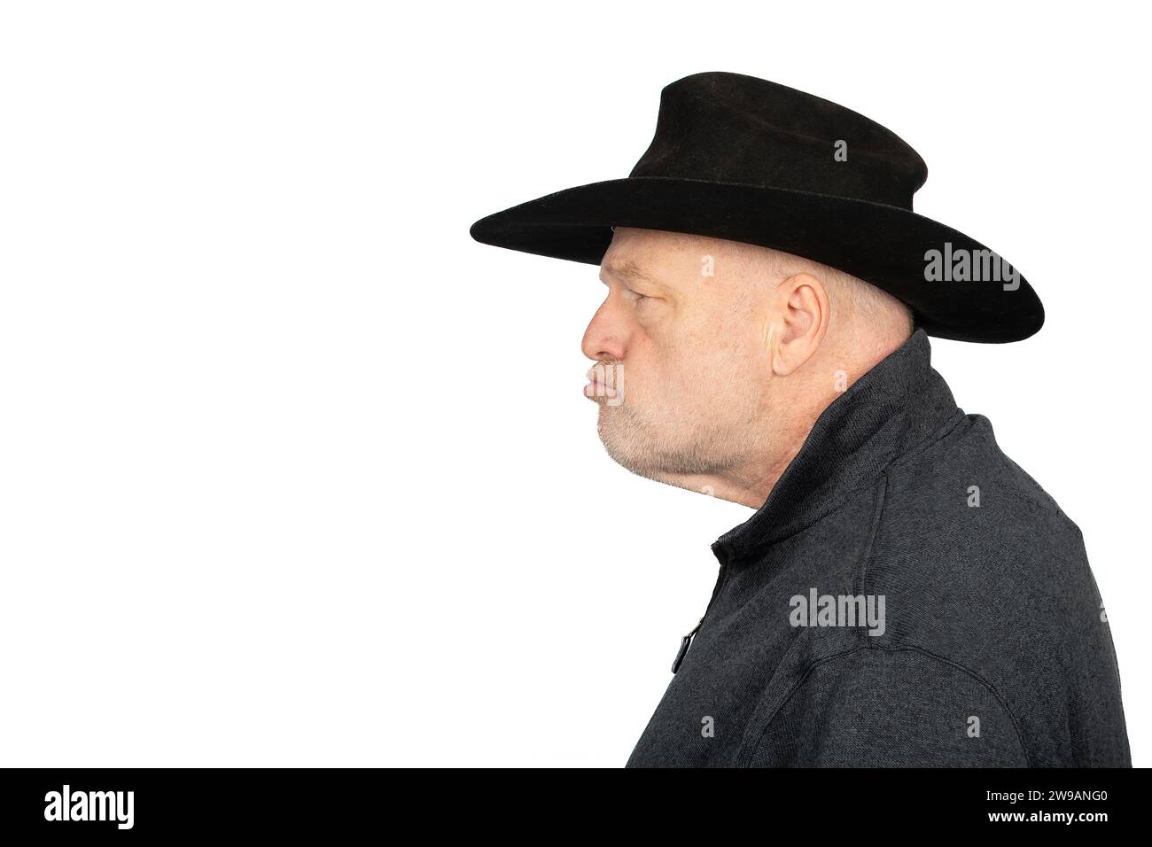 Cow-boy d'âge moyen sérieux, fermier regardant à gauche, isolé sur fond blanc. Banque D'Images
