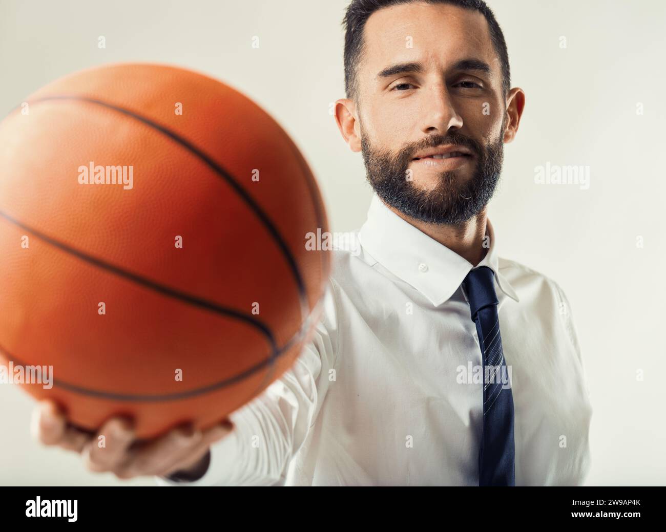 Dirigeant déterminé avec un basketball symbolise le travail d'équipe et l'établissement d'objectifs dans un contexte d'affaires Banque D'Images