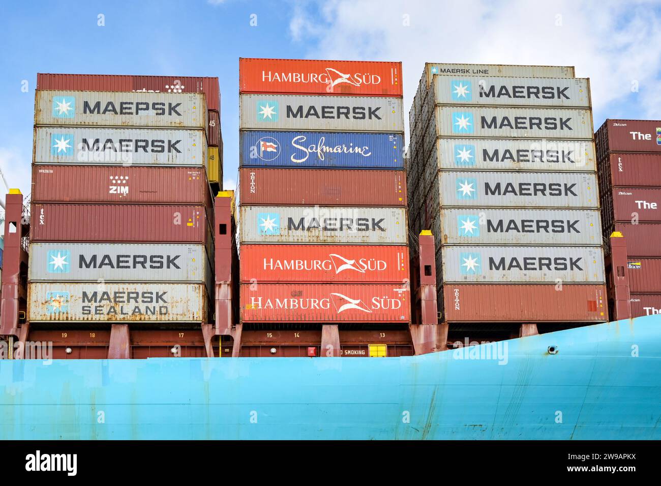 Miami, Floride, États-Unis - 1 décembre 2023 : conteneurs d'expédition empilés haut sur le côté d'un cargo porte-conteneurs dans les docks de Miami Banque D'Images