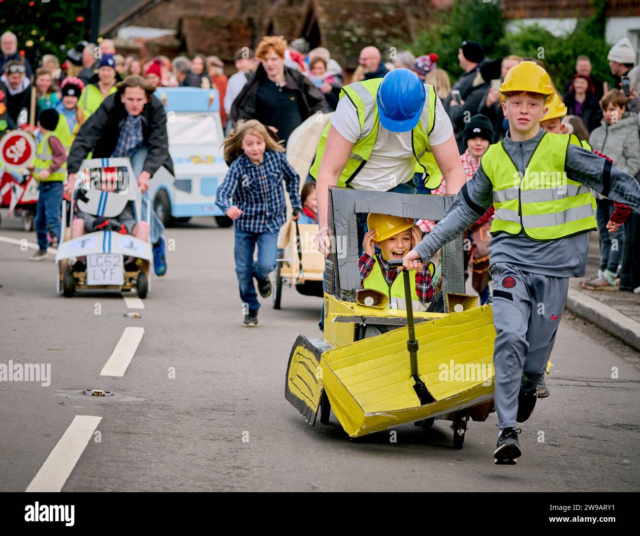 East Hoathly, Royaume-Uni. 26 décembre 2023. Course de poussettes le lendemain de Noël : des équipes en robe de fantaisie font la course dans le village d'East Hoathly dans l'East Sussex pour recueillir des fonds pour des œuvres caritatives locales. L'événement annuel commence et se termine au pub Kings Head au centre du village. Crédit : Jim Holden/Alamy Live News Banque D'Images