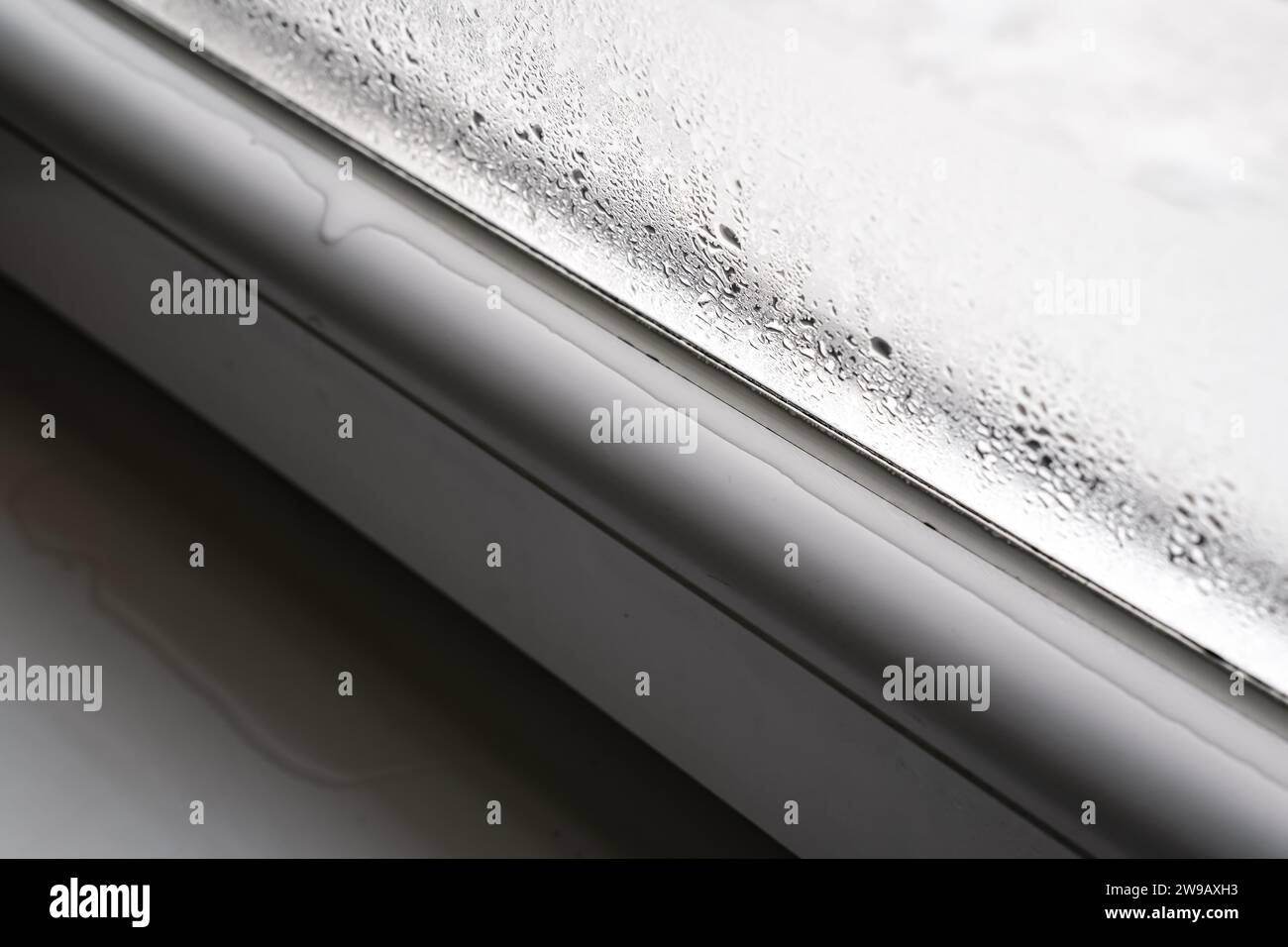 Gouttes d'eau condensées à la fenêtre froide pendant la saison d'hiver, détail gros plan. Banque D'Images