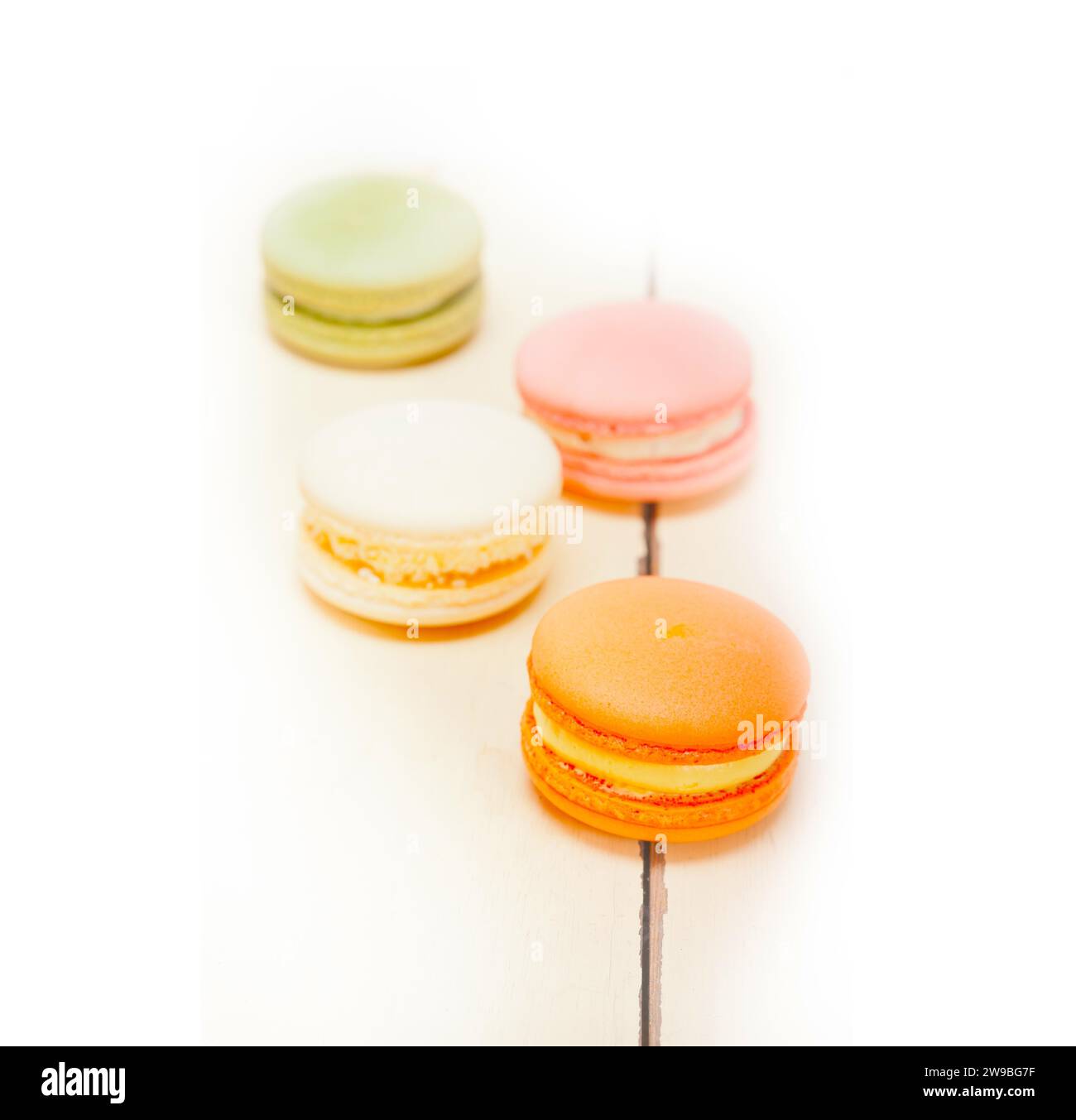 Macarons français colorés sur une table en bois rustique blanc, photographie de nourriture Banque D'Images