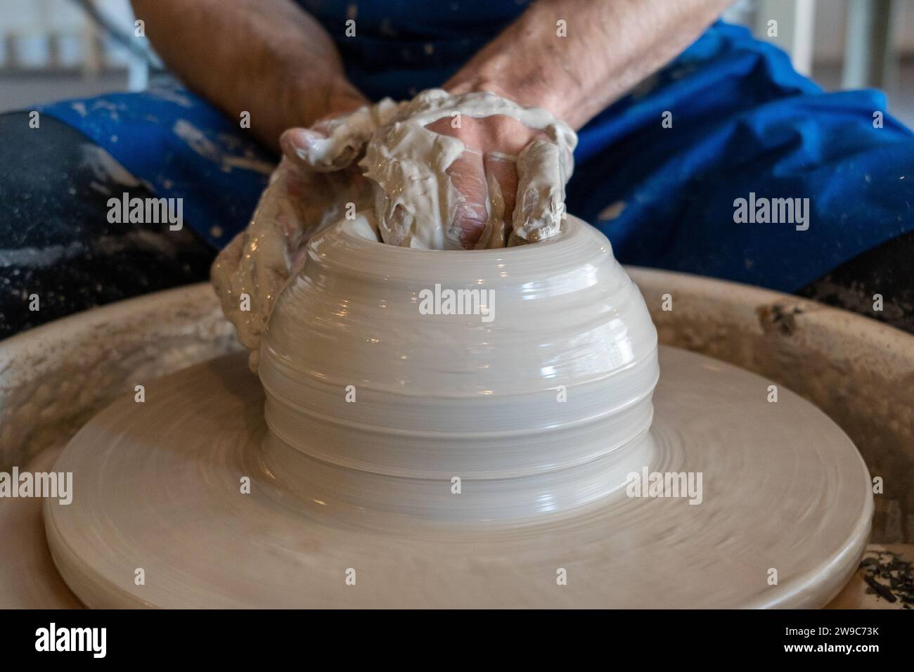 Potier jetant un pot sur la roue dans un studio. Photo de haute qualité. Hobby, agitation latérale, activité Banque D'Images