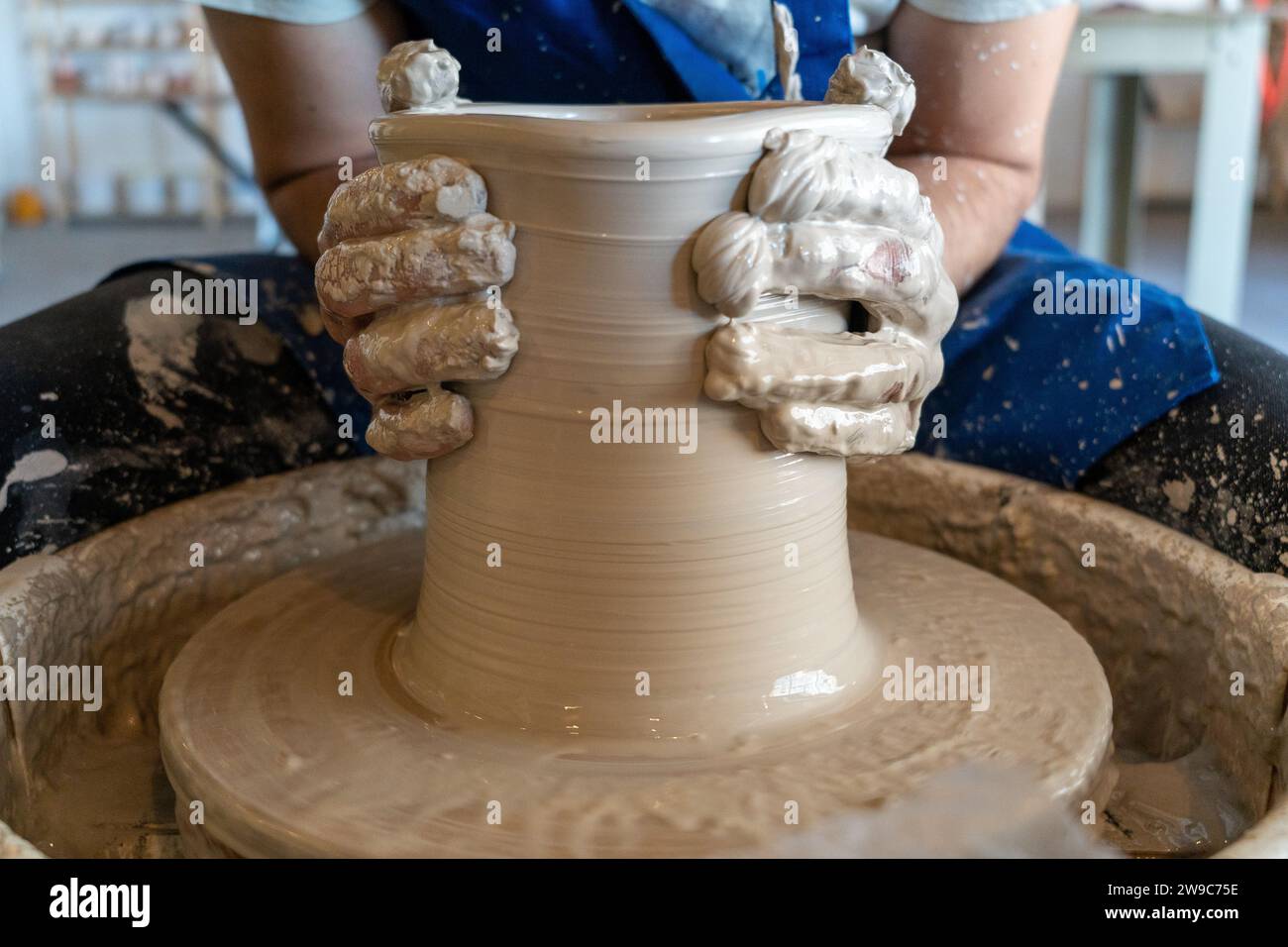 Potier jetant un pot sur la roue dans un studio. Photo de haute qualité. Hobby, agitation latérale, activité Banque D'Images