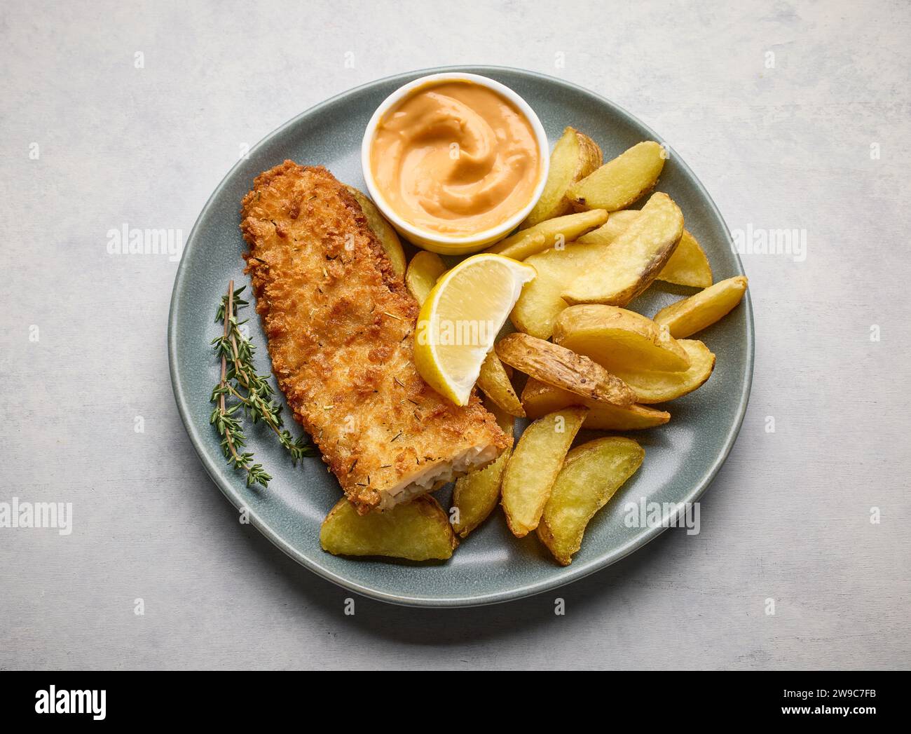 assiette de fish and chips, filet de poisson pané et tranches de pommes de terre frites sur la table de cuisine lumineuse, vue de dessus Banque D'Images