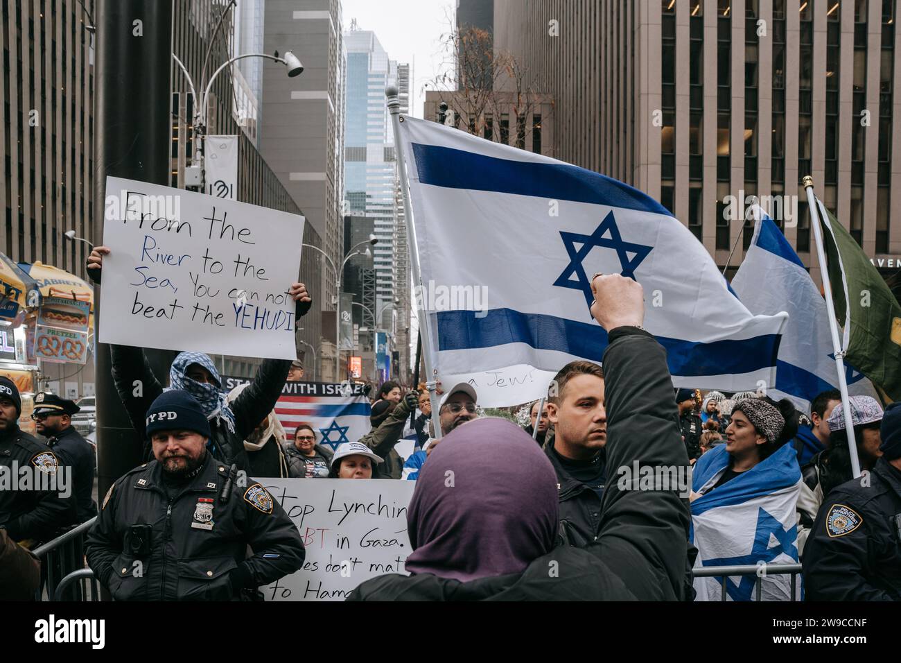 New York, États-Unis. 25 décembre 2023. Les manifestants pro-palestiniens affrontent un petit groupe de manifestants pro-israéliens pendant la manifestation. Le jour de Noël, après avoir construit une scène de nativité avec des décombres, du faux sang et des poupées inusées, des centaines de partisans de la Palestine à New York descendent dans la rue pour appeler à un cessez-le-feu immédiat à Gaza. La manifestation est organisée en solidarité avec les églises chrétiennes de Bethléem, qui ont annulé les célébrations de Noël en raison du bombardement continu de Gaza. Crédit : SOPA Images Limited/Alamy Live News Banque D'Images