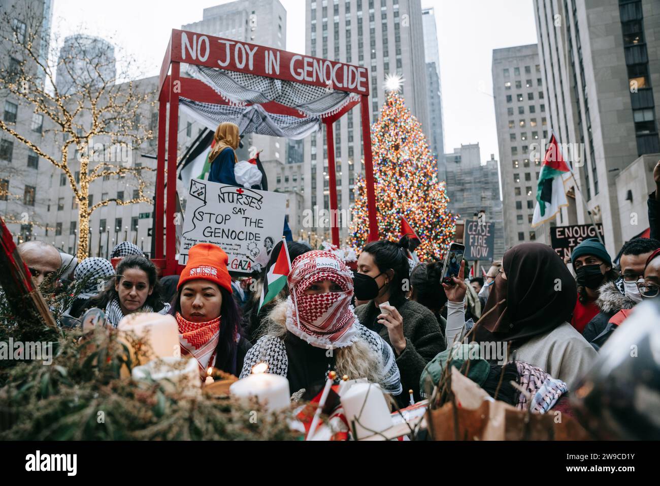 Une foule de manifestants est vue et dans leur arrière-plan se trouve une plate-forme avec l'inscription "No Joy in Genocide" pendant la manifestation. Le jour de Noël, après avoir construit une scène de nativité avec des décombres, du faux sang et des poupées inusées, des centaines de partisans de la Palestine à New York descendent dans la rue pour appeler à un cessez-le-feu immédiat à Gaza. La manifestation est organisée en solidarité avec les églises chrétiennes de Bethléem, qui ont annulé les célébrations de Noël en raison du bombardement continu de Gaza. (Photo Olga Fedorova/SOPA Images/Sipa USA) Banque D'Images