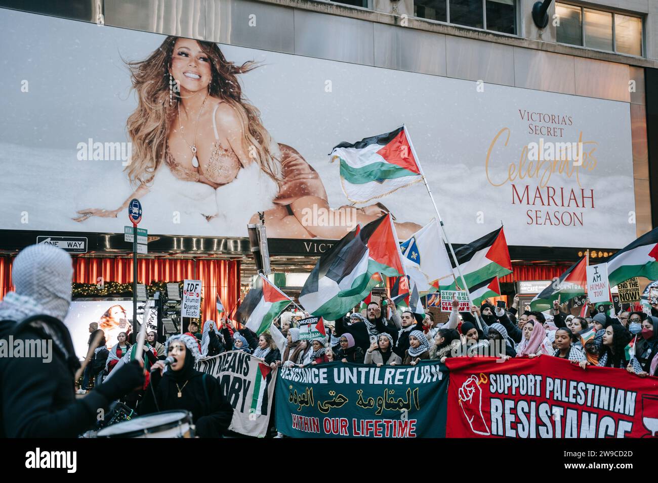 New York, États-Unis. 25 décembre 2023. Les manifestants brandissent des drapeaux palestiniens, des pancartes et des banderoles pendant la manifestation. Le jour de Noël, après avoir construit une scène de nativité avec des décombres, du faux sang et des poupées inusées, des centaines de partisans de la Palestine à New York descendent dans la rue pour appeler à un cessez-le-feu immédiat à Gaza. La manifestation est organisée en solidarité avec les églises chrétiennes de Bethléem, qui ont annulé les célébrations de Noël en raison du bombardement continu de Gaza. Crédit : SOPA Images Limited/Alamy Live News Banque D'Images