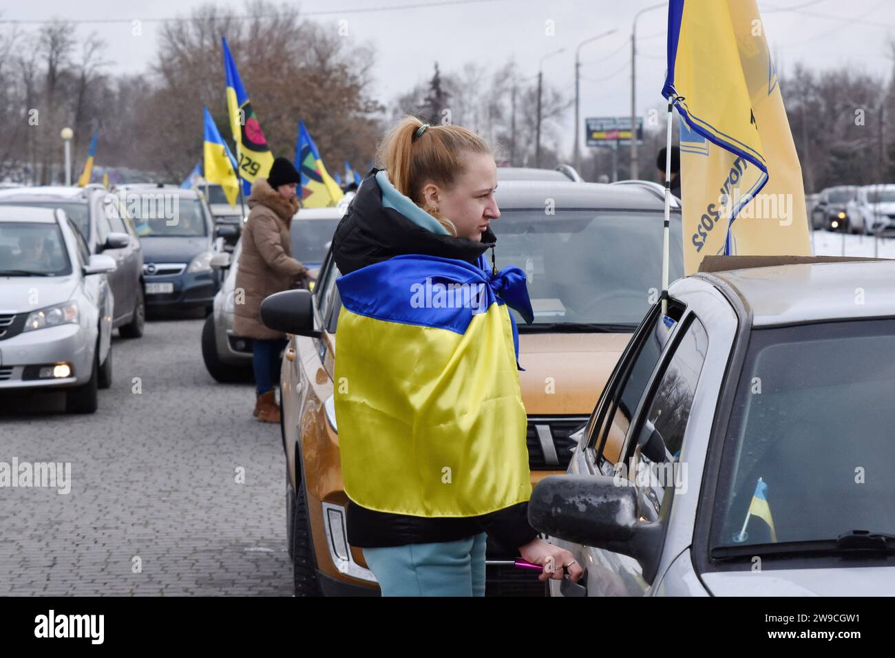 Les manifestants se tiennent près de leurs voitures décorées de banderoles avant le début du rassemblement automobile en soutien aux prisonniers de guerre ukrainiens sous le slogan "ne te taisez pas! La captivité tue ! » À Zaporizhzhia. Le président ukrainien Volodymyr Zelenskyy a déclaré que le processus d'échange de prisonniers de guerre a été entravé par la Russie pour des raisons spécifiques, mais il espère que cette voie s'ouvrira bientôt. « Nous travaillons maintenant à ramener un nombre assez décent de nos gars. Si Dieu le veut, nous réussirons », a-t-il déclaré lors de sa conférence de presse de fin d'année le 19 décembre 2023. Banque D'Images