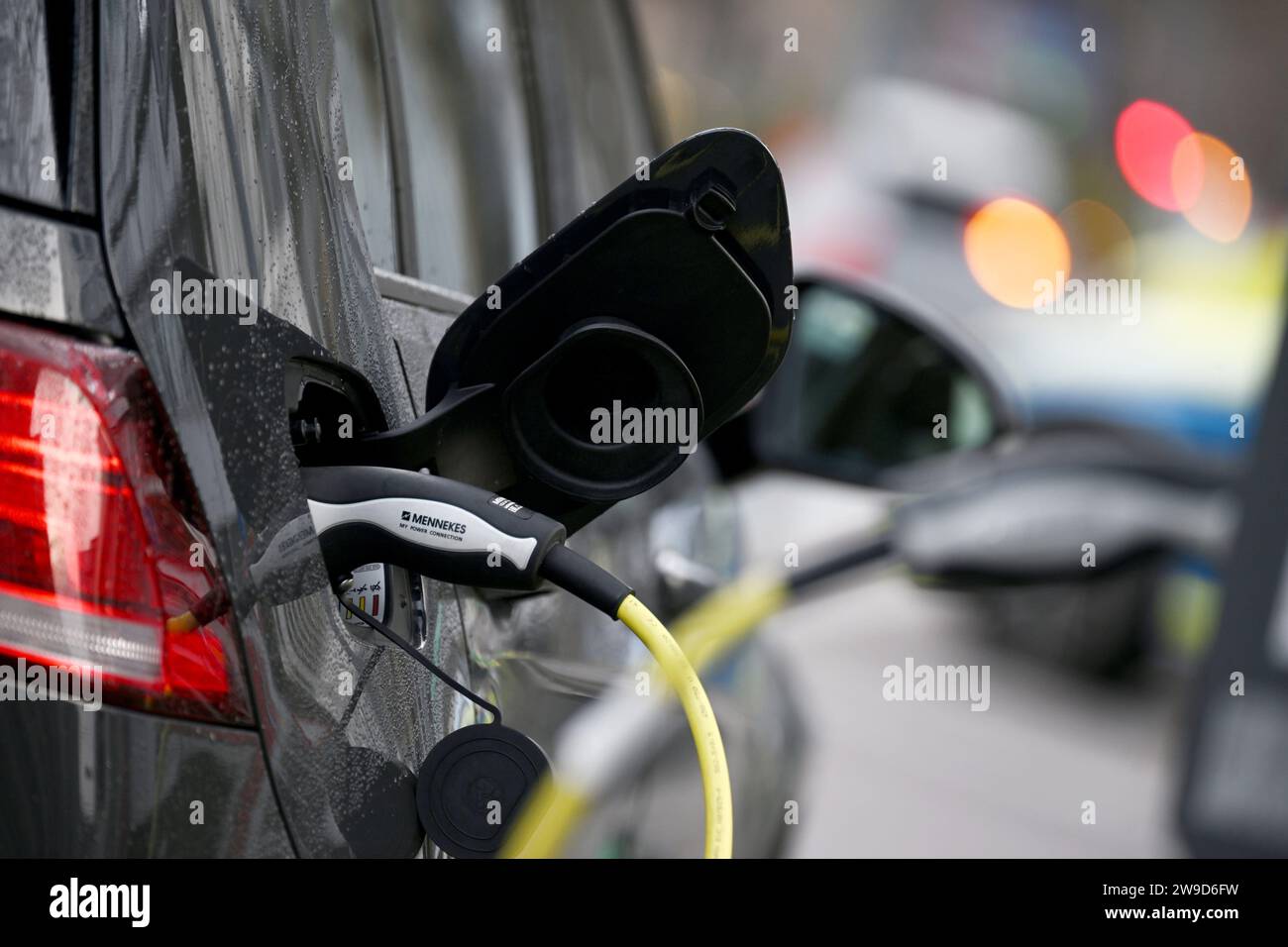 Stuttgart, Allemagne. 27 décembre 2023. Une voiture électrique étant chargée à une borne de recharge dans le centre-ville. Afin de réduire au plus vite les émissions de CO2 dans le secteur des transports, Hermann, ministre des Transports du Bade-Württemberg, estime qu'une expansion rapide de l'e-mobilité est la meilleure solution. Crédit : Marijan Murat/dpa/Alamy Live News Banque D'Images Stuttgart, Allemagne. 27 décembre 2023. Une voiture électrique étant chargée à une borne de recharge dans le centre-ville. Afin de réduire au plus vite les émissions de CO2 dans le secteur des transports, Hermann, ministre des Transports du Bade-Württemberg, estime qu'une expansion rapide de l'e-mobilité est la meilleure solution. Crédit : Marijan Murat/dpa/Alamy Live News Banque D'Images