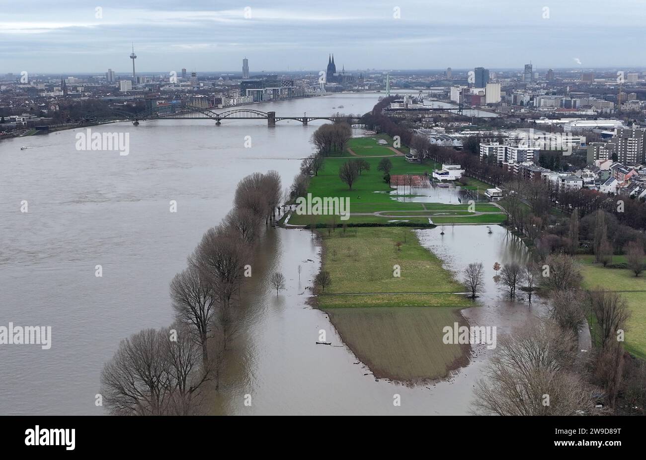 Cologne, Allemagne. 27 décembre 2023. Les prairies de bornes sur les rives du Rhin sont sous l’eau (photo prise avec un drone). Le niveau d'eau à la jauge de Cologne devait atteindre un pic mercredi soir. Crédit : Sascha Thelen/dpa/Alamy Live News Banque D'Images