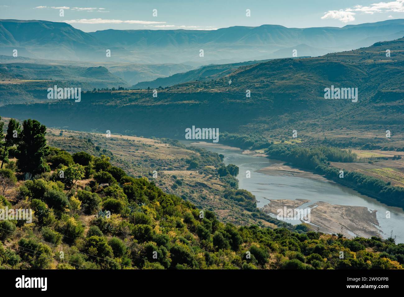 Une large rivière serpente à travers une vallée du Lesotho vers les montagnes Banque D'Images