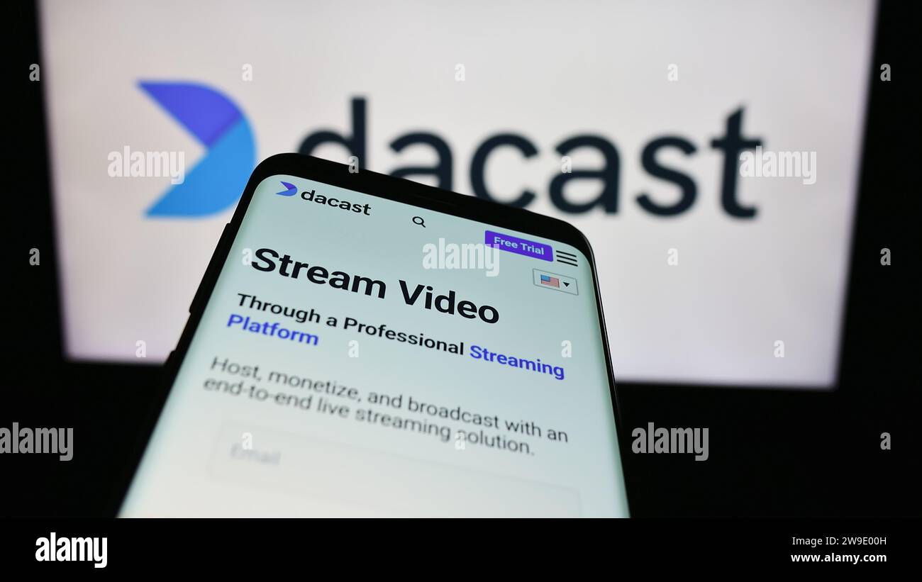 Smartphone avec le site Web de la société de streaming vidéo en direct Dacast Inc. Devant le logo de l'entreprise. Effectuez le focus sur le coin supérieur gauche de l'écran du téléphone. Banque D'Images