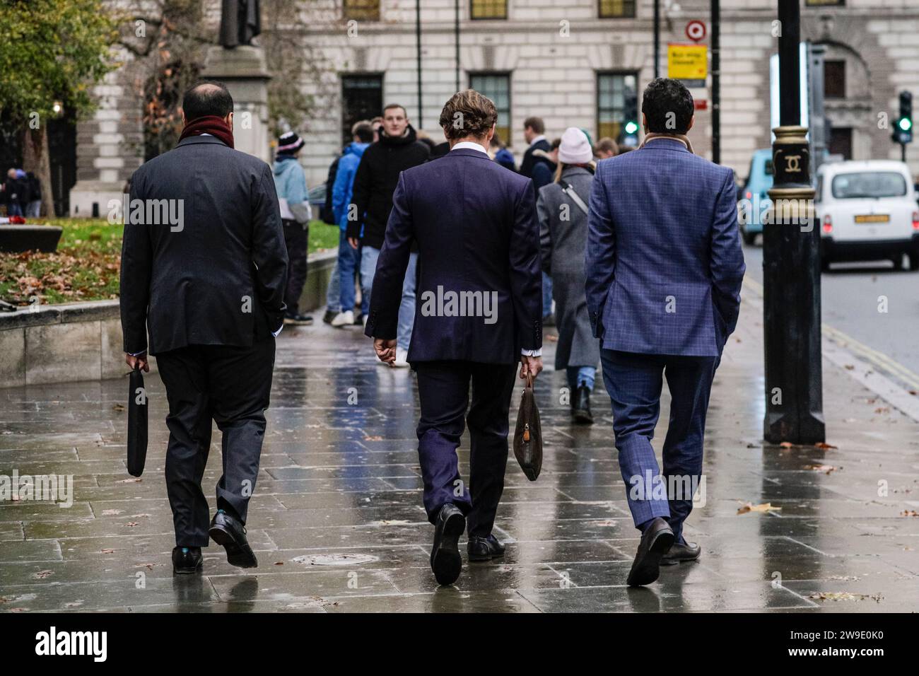 Groupe de trois hommes en costume marchant de retour à la caméra à Westminster, Londres, Angleterre Banque D'Images