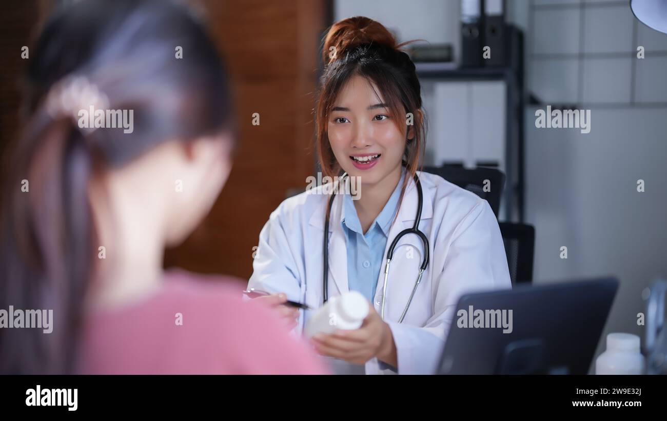 Femmes psychologue asiatique pointant sur la bouteille de pilules pour expliquer la médecine et la prescription au patient féminin tout en donnant des conseils sur médical et Banque D'Images