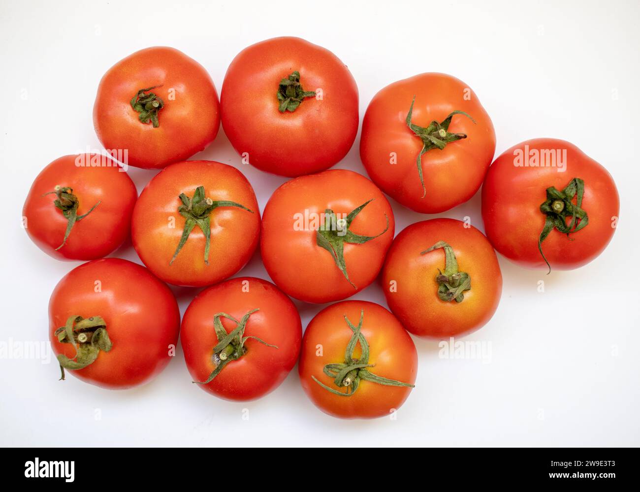 Tomates fraîches et juteuses isolées sur tomates blanches biologiques. Banque D'Images