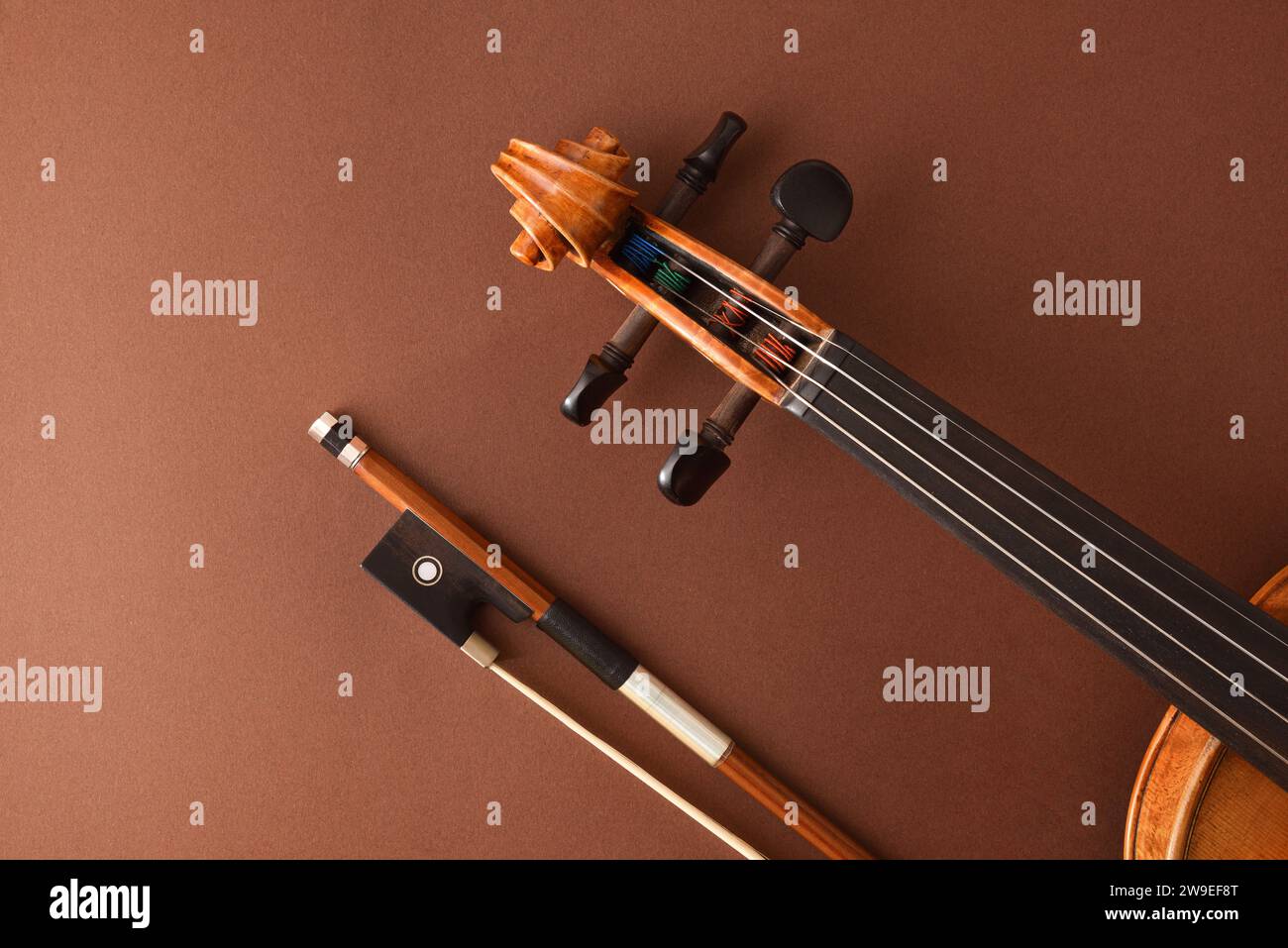 Détail de la boîte à broches et touche de violon à cordes traditionnel et arc sur fond brun dégradé isolé.. Vue de dessus. Banque D'Images