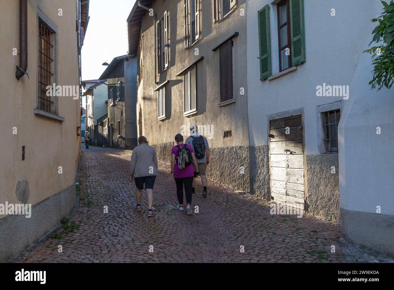 Gens marchant dans la rue d'un village suisse, Meride, Tessin, Suisse Banque D'Images
