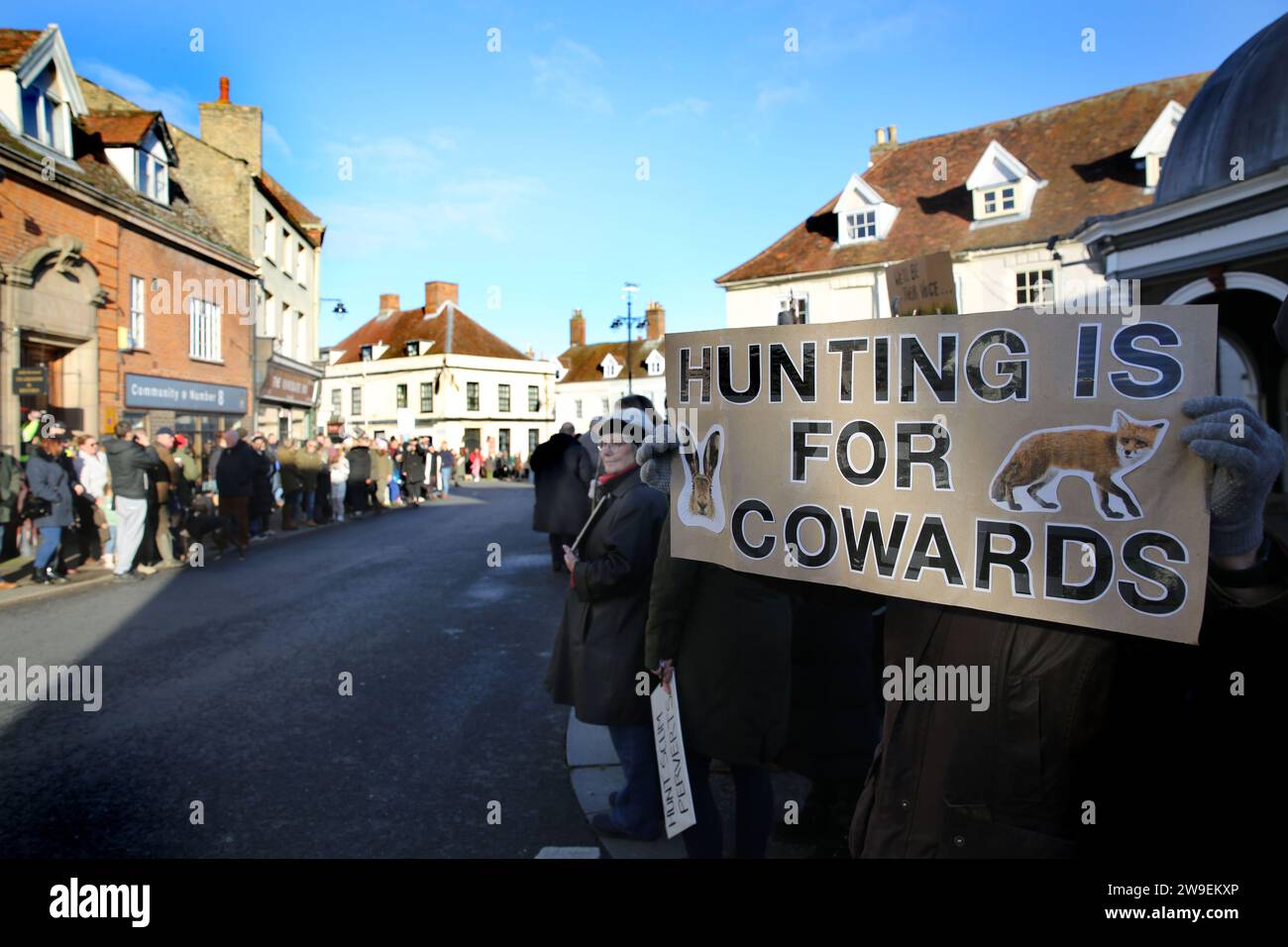 Un manifestant tient une pancarte disant « la chasse, c’est pour les lâches » pendant la manifestation. Action contre la cruauté envers les animaux, une manifestation a eu lieu dans le centre-ville de Bungay alors que les Harriers de Waveney et Norfolk défilent dans les rues pour soutenir la campagne. Les manifestants ont déclaré que, bien qu'il s'agisse d'une interdiction de la chasse traditionnelle au renard, les animaux sont toujours tués pendant l'alternative de la chasse au sentier et ils appellent à une interdiction totale. Banque D'Images