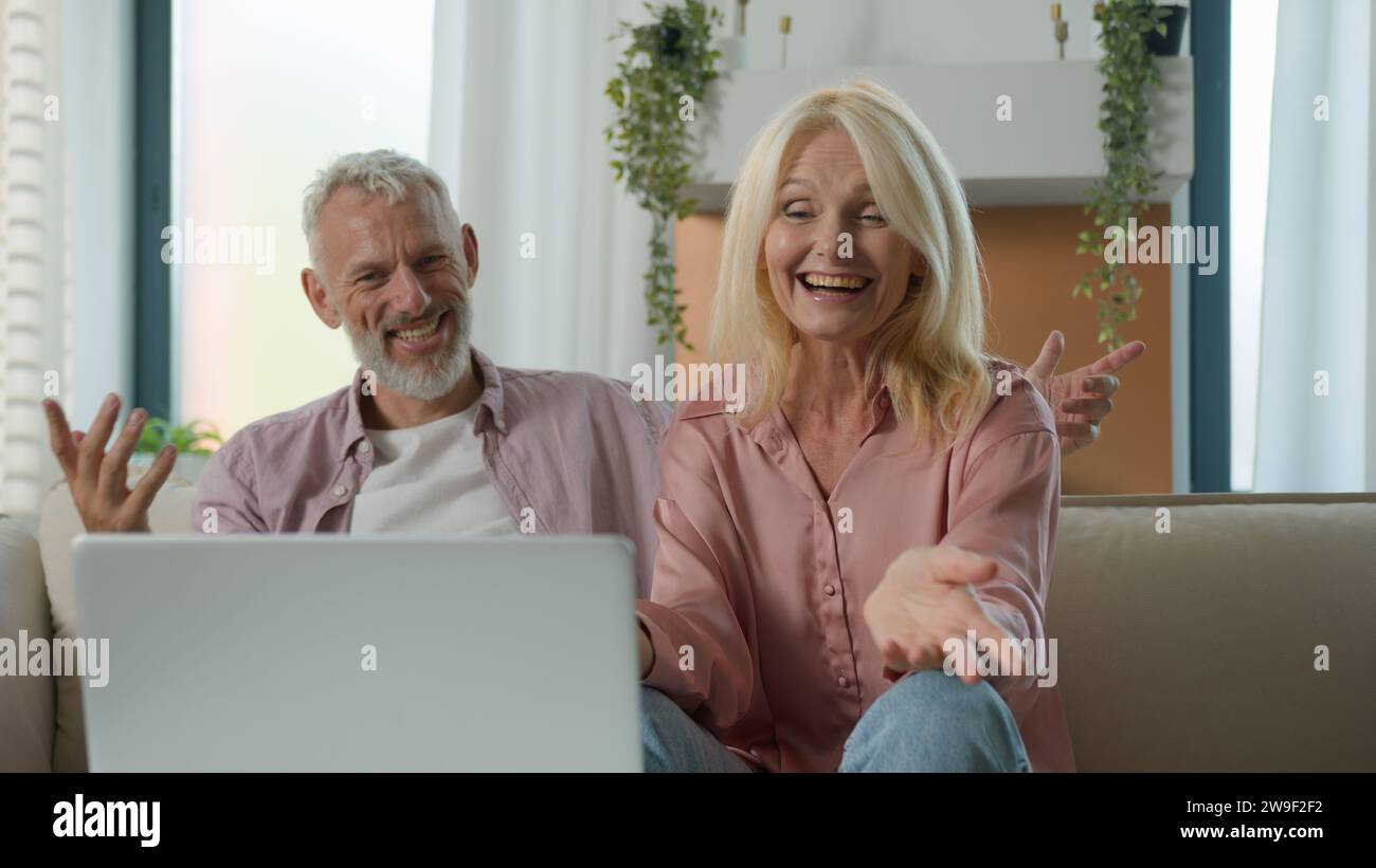 Heureux satisfait caucasien marié couple grand-père grand-mère homme femme parlant sur appel vidéo en utilisant un ordinateur portable à la maison canapé réunion en ligne avec Banque D'Images