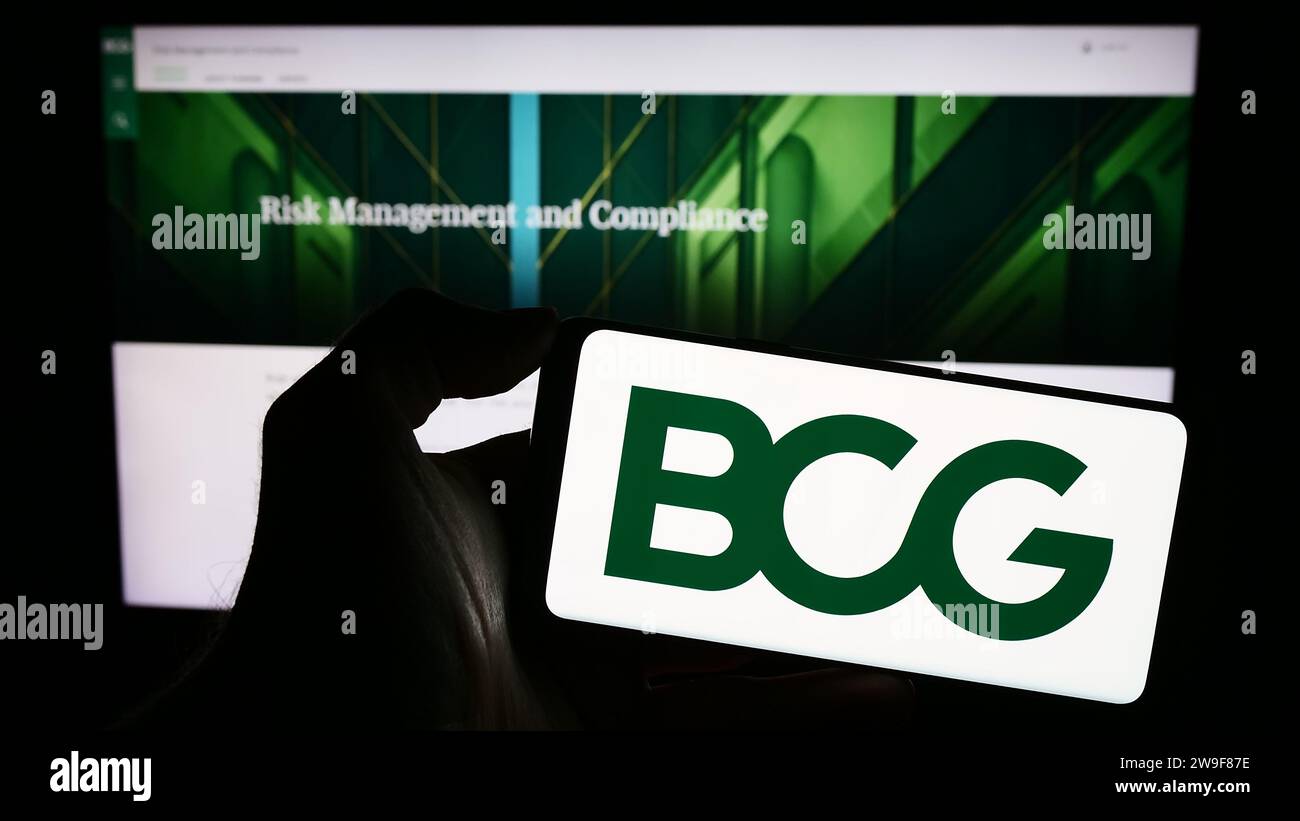 Personne détenant un téléphone cellulaire avec le logo de la société américaine Boston Consulting Group Inc. (BCG) devant la page Web de l'entreprise. Concentrez-vous sur l'affichage du téléphone. Banque D'Images