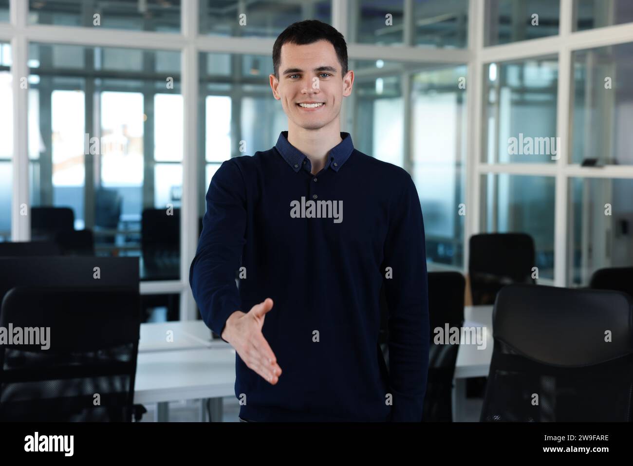 Homme heureux accueillant et offrant poignée de main dans le bureau Banque D'Images