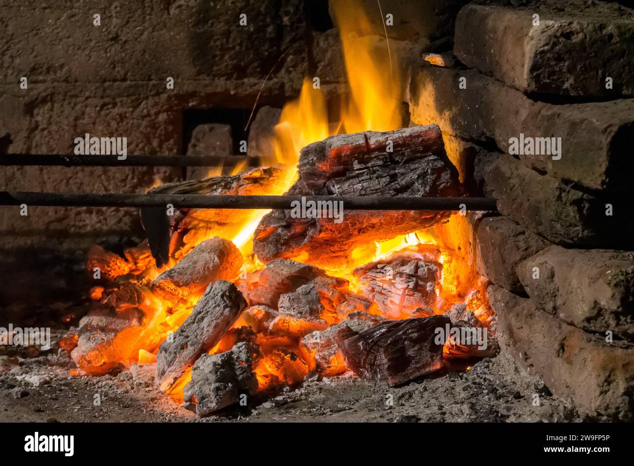 Prise de vue nocturne de braises brillantes avec feu dans un feu de camp Banque D'Images