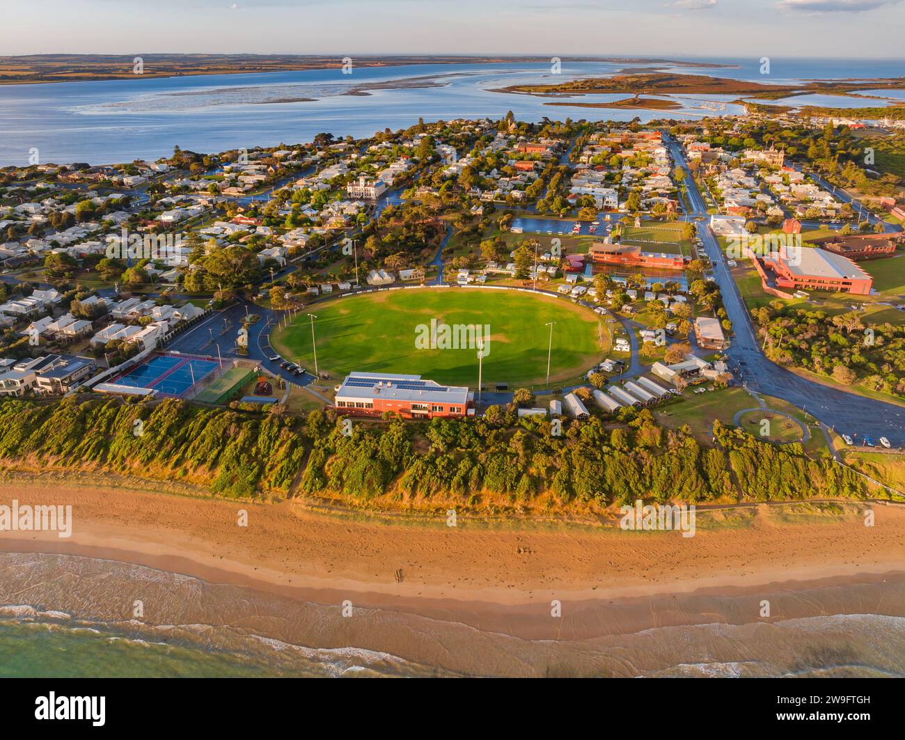Vue aérienne d'un township côtier autour d'un ovale sportif au-dessus d'une plage de sable à Queenscliff sur la péninsule de Bellarine à Victoria, Australie. Banque D'Images