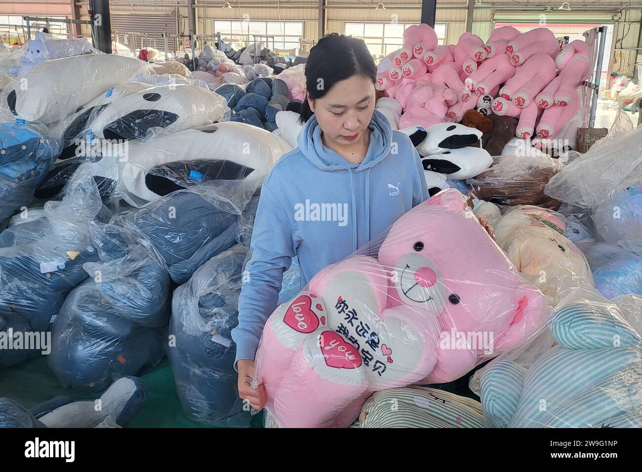 LIANYUNGANG, CHINE - 28 DÉCEMBRE 2023 - les travailleurs transforment des jouets en peluche pour l'exportation dans une usine de jouets dans la ville de Lianyungang, province de Jiangsu en Chine orientale, de Banque D'Images