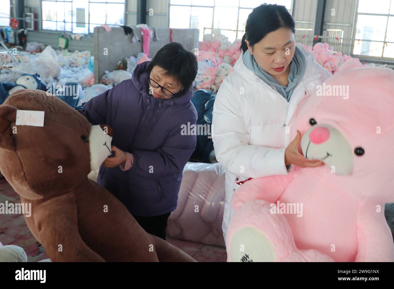 LIANYUNGANG, CHINE - 28 DÉCEMBRE 2023 - les travailleurs transforment des jouets en peluche pour l'exportation dans une usine de jouets dans la ville de Lianyungang, province de Jiangsu en Chine orientale, de Banque D'Images