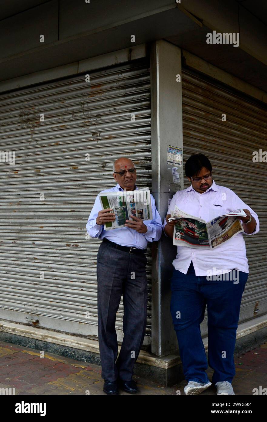 Des hommes mahrati lisant le journal du matin à Dadar, Mumbai, Inde. Banque D'Images