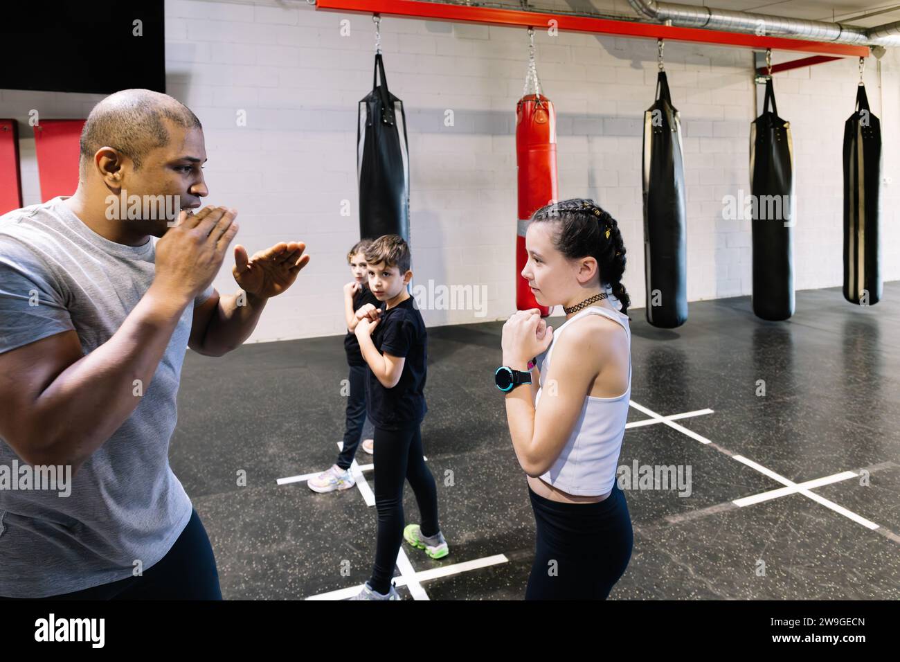 Photo horizontale étudiants d'une école de boxe vêtus de vêtements de sport, s'échauffant dans une salle de gym. Sport, concept de loisirs. Banque D'Images