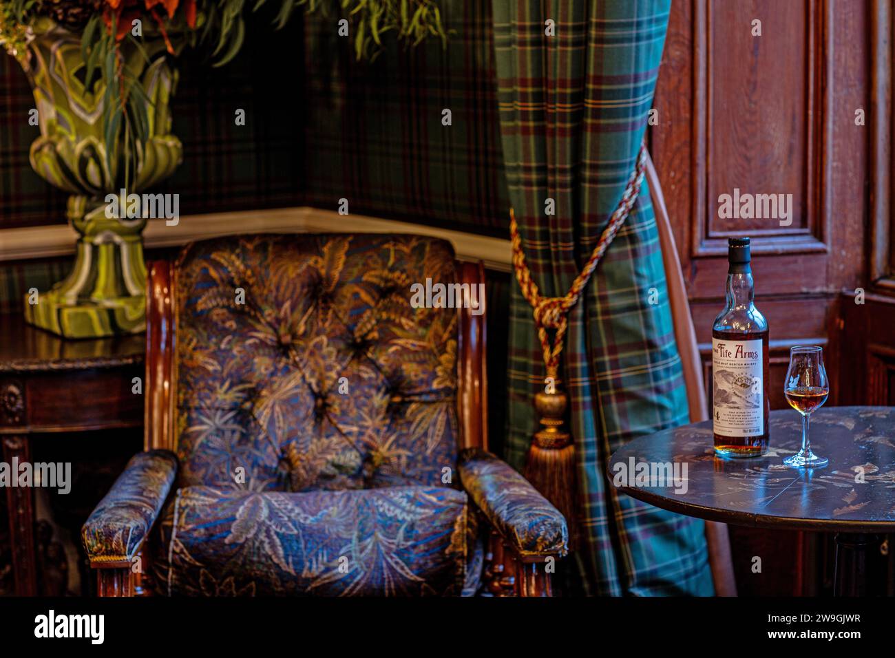 Bouteille de whisky single malt avec verre à whisky sur la table dans le salon Banque D'Images