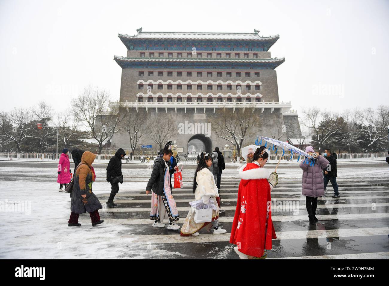 (231228) -- PÉKIN, 28 déc. 2023 (Xinhua) -- les gens marchent devant la tour fléchée de la porte Zhengyang après une chute de neige à Pékin, capitale de la Chine, le 14 décembre 2023. Créé sous la dynastie Yuan (1271-1368), l'axe central de Pékin, ou Zhongzhouxian, s'étend sur 7,8 kilomètres entre la porte de Yongding au sud de la ville et la Tour du tambour et du clocher au nord. La plupart des grands bâtiments de la vieille ville de Pékin se trouvent le long de cet axe. Portes, palais, temples, places et jardins de la vieille ville sont tous reliés à l'axe. Comme ils ont été témoins des activités folkloriques le long de la ligne de o Banque D'Images