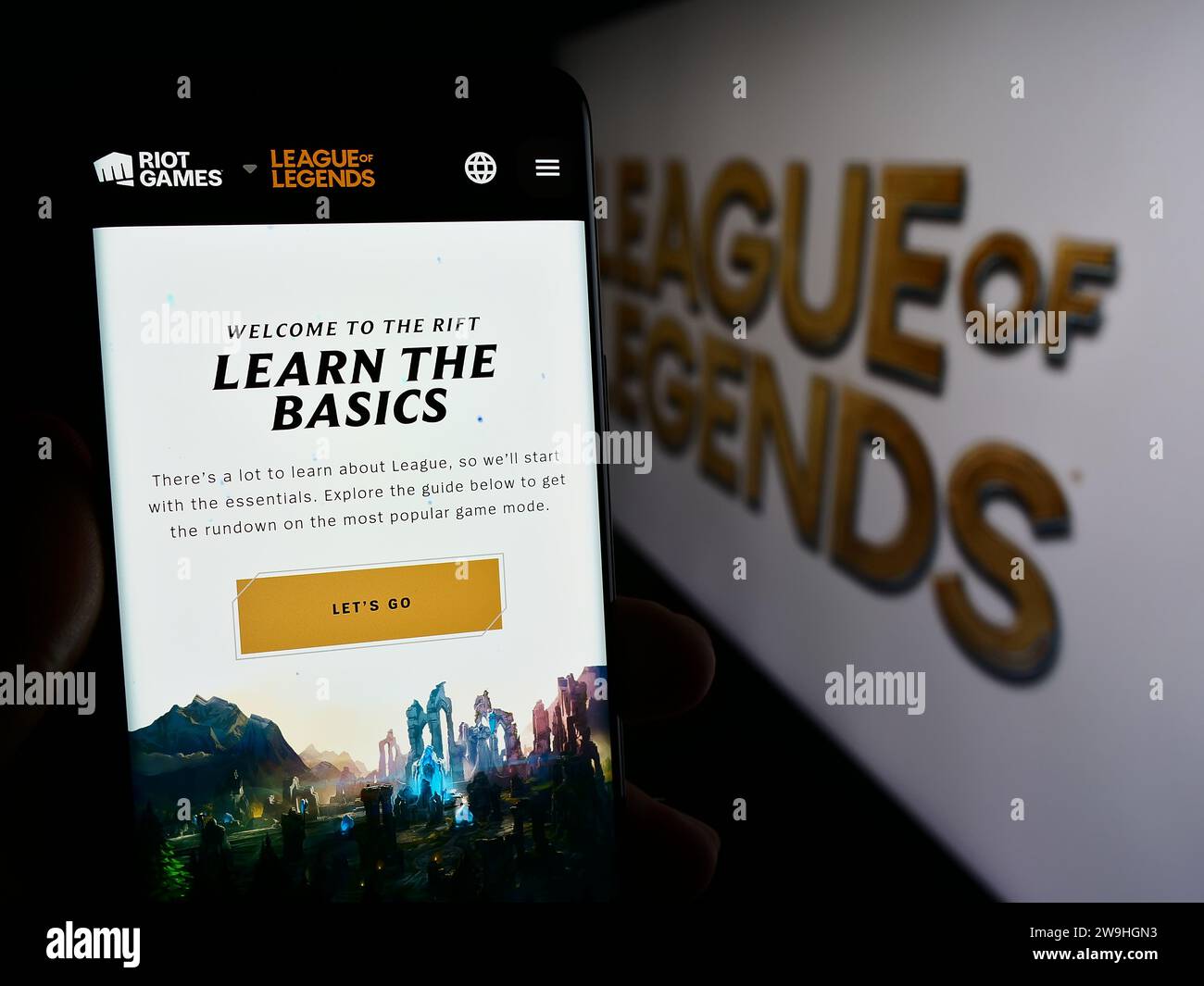 Personne tenant le téléphone mobile avec la page Web du jeu vidéo multijoueur en ligne League of Legends (LOL) avec logo. Concentrez-vous sur le centre de l'écran du téléphone. Banque D'Images