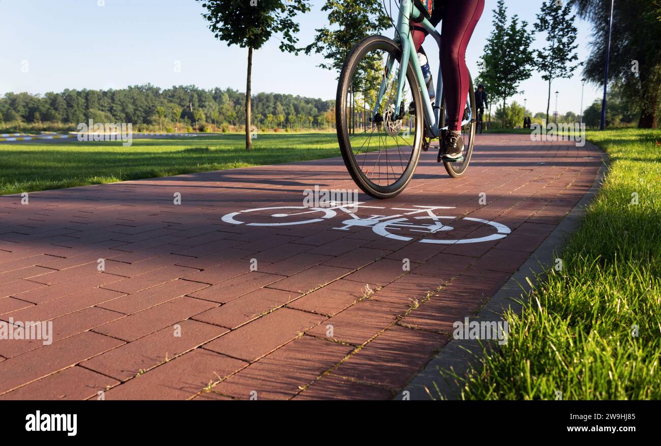 Jeune fille active se promène sur une piste cyclable dans un parc de la ville tôt le matin. Concept de loisirs. Banque D'Images