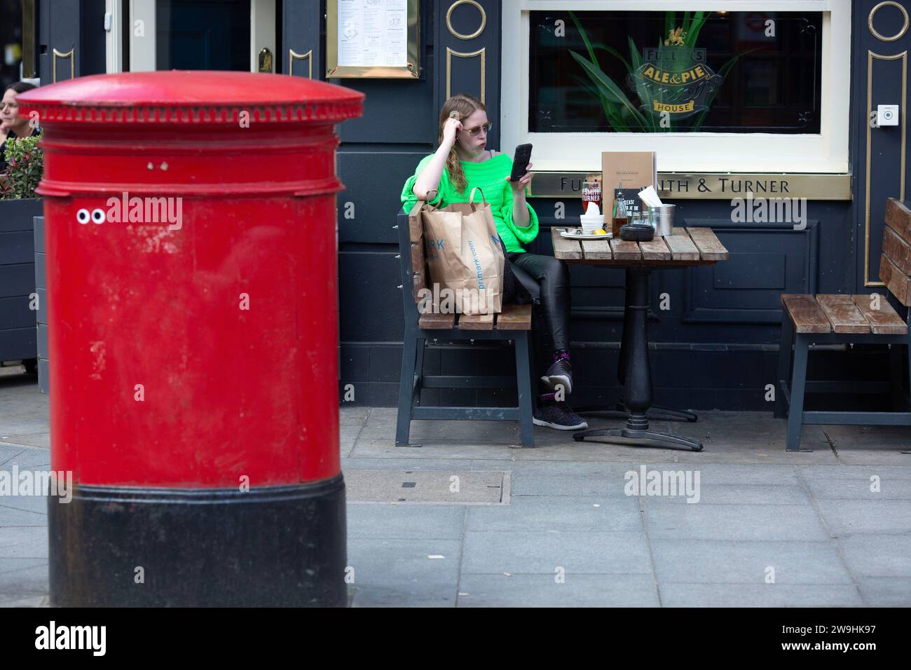 Un acheteur se repose devant un pub dans le centre de Londres, le Vendredi Saint. Banque D'Images