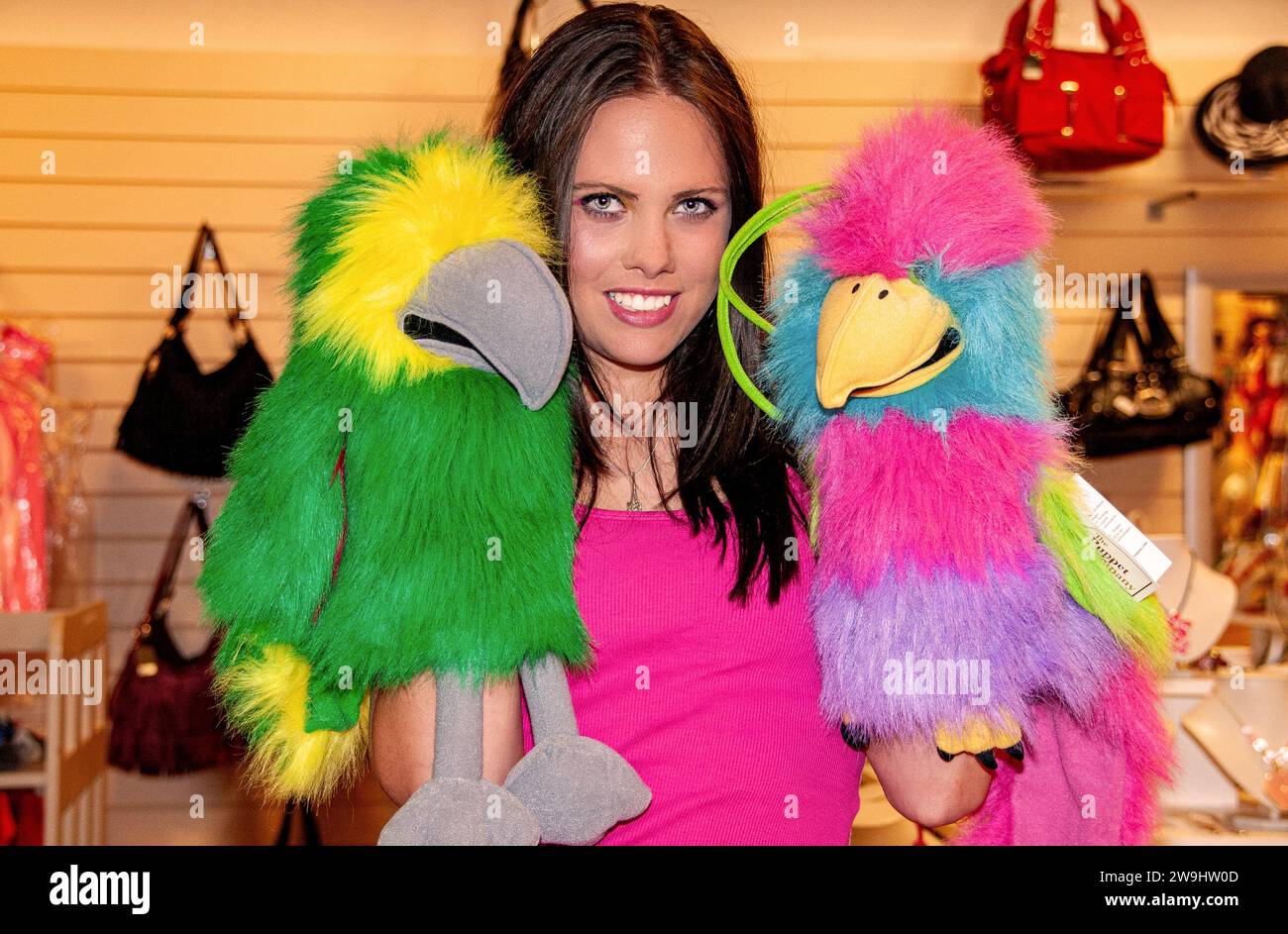 Dans une boutique, une femme glamour s’amuse à modeler tout en jouant avec des marionnettes à gants à Dundee, en Écosse Banque D'Images