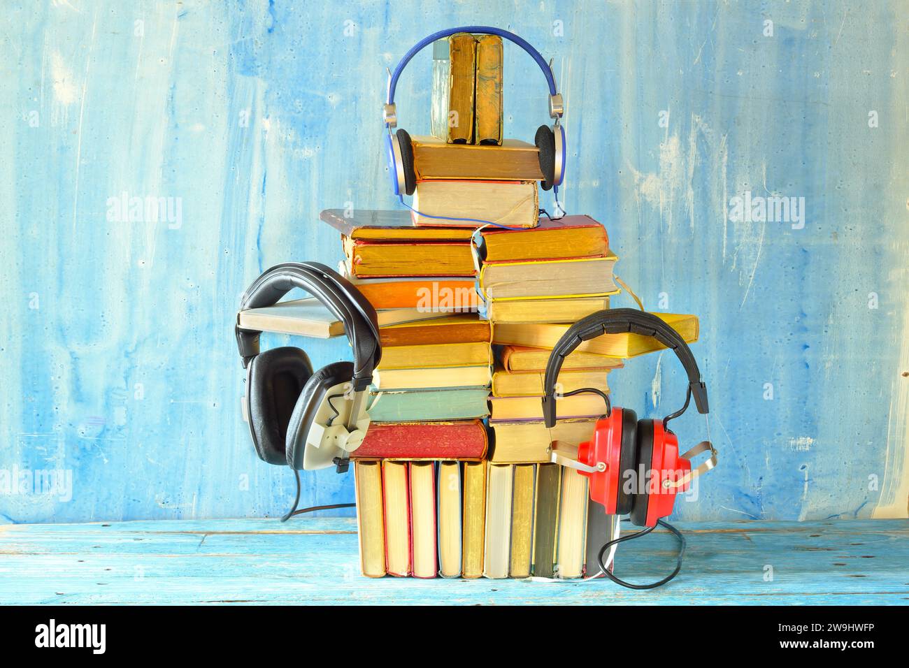 concept de livre audio avec tas de livres et ensemble de casques vintage, fond grungy, espace de copie libre Banque D'Images