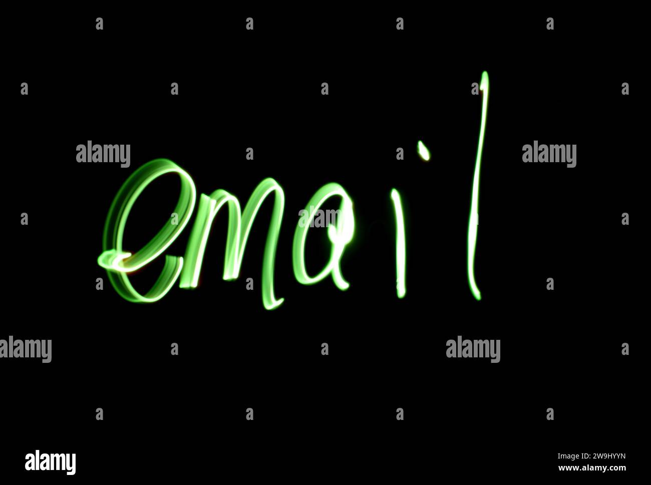 Photographie du mot « e-mail » écrit en lumière verte éclatante sur une photo longue exposition sur fond noir. Photographie de peinture légère Banque D'Images