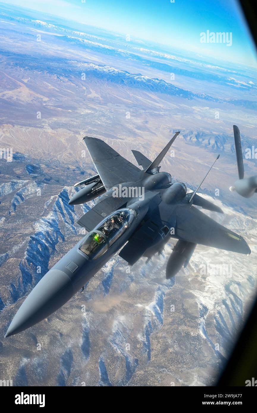 Base aérienne de Nellis, États-Unis. 11 décembre 2023. Un avion de chasse F-15E Strike Eagle de l'US Air Force se détache après un ravitaillement en vol par un KC-135 Stratotanker de l'USAF pendant le cours d'intégration d'armes sur le champ d'essais et d'entraînement du Nevada, le 12 décembre 2023 au-dessus de la base aérienne de Nellis, Nevada. Crédit : SRA Haiden Morris/Planetpix/Alamy Live News Banque D'Images